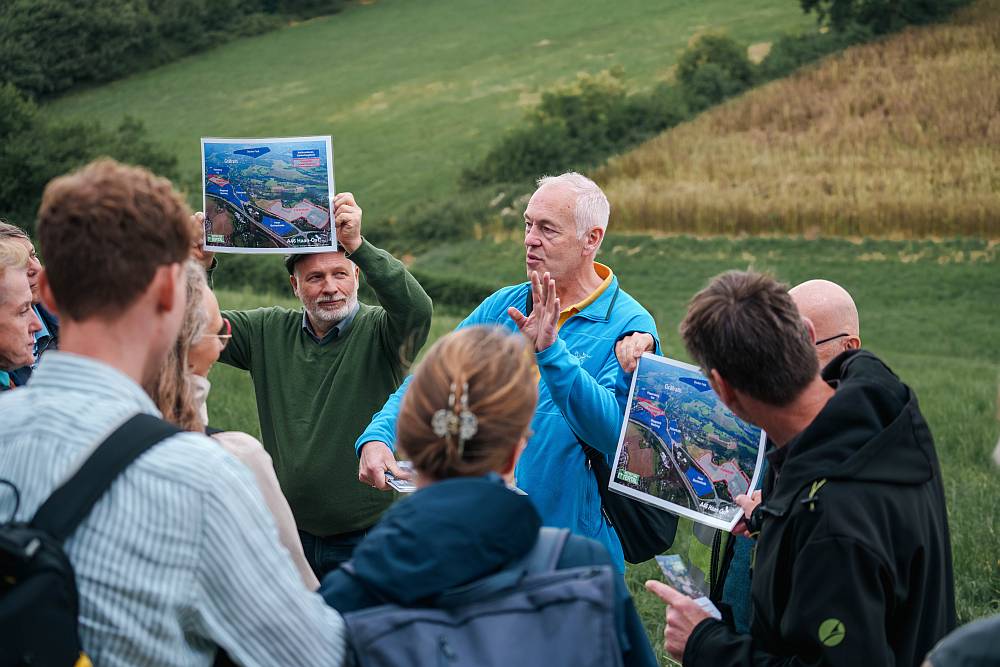 Die Bürgerinitiative Rettet das Ittertal informiert über den aktuellen Stand der geplanten Gewerbegebiete, von denen eines im Hintergrund zu sehen ist (Foto: Simon van de Loo)